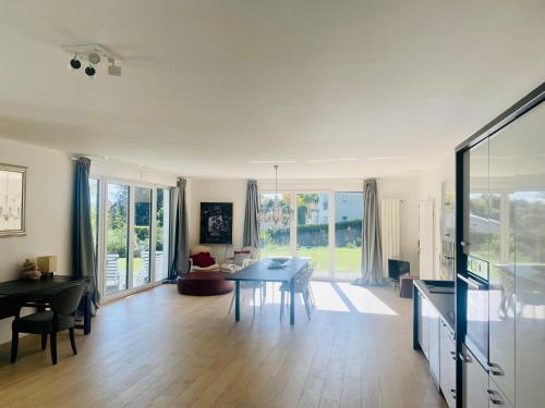 a living room with a table and a dining room at Mansion Lake Starnberg in Feldafing