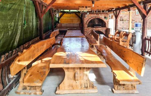 a row of wooden tables and benches in a building at Lovely Home In Vinogradi Ludbreski in Ludbreg