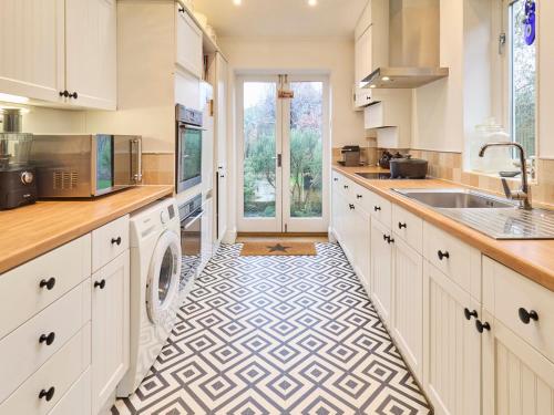 坎特伯雷的住宿－Host & Stay - Roper Villa，厨房配有白色橱柜和瓷砖地板。