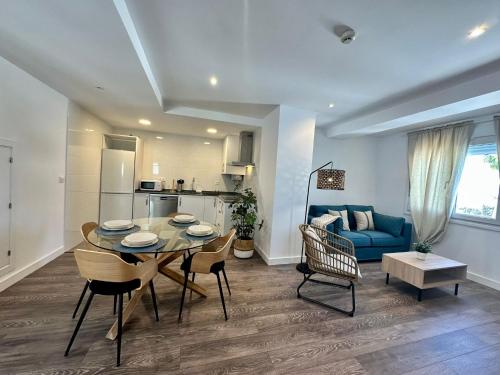 ein Wohnzimmer mit einem Tisch und einem blauen Sofa in der Unterkunft La Muralla Playa y Ascensor Grupo AC Gestion in Cádiz
