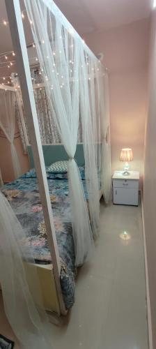 1 dormitorio con 1 cama con cortinas y mesita de noche en ROSHAN STAYs, en Bangalore