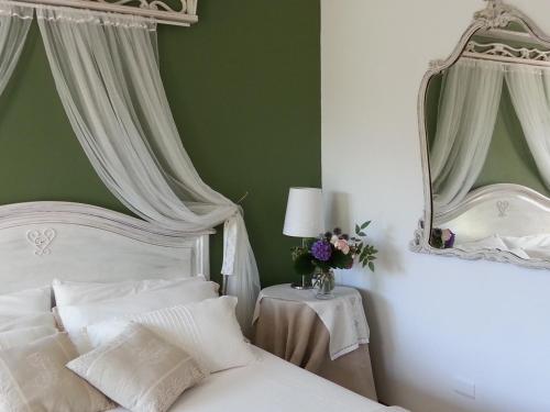 a bedroom with a white bed and a green wall at Villa San Giorgio in Pellio Superiore