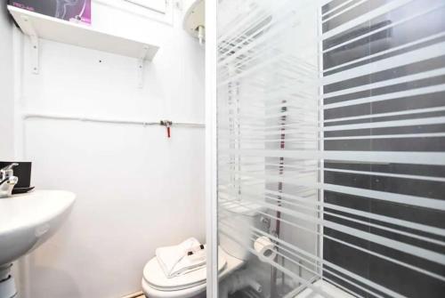 une salle de bain avec toilettes et douche en verre dans l'établissement Cosy Studio Neuilly, à Neuilly-sur-Seine