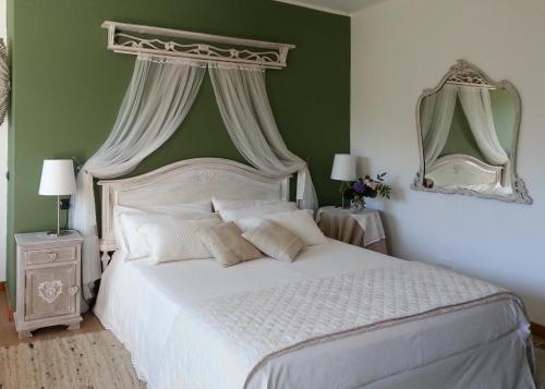 a bedroom with a white bed and a green wall at Villa San Giorgio in Pellio Superiore