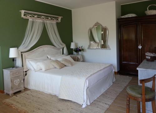 Villa San Giorgio في Pellio Superiore: غرفة نوم بسرير ابيض وجدار اخضر