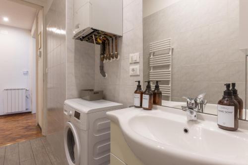 ein Badezimmer mit einem Waschbecken und einer Waschmaschine in der Unterkunft Palladio due - spazioso 3 camere in Triest