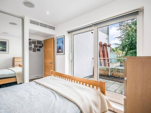 a bedroom with a bed and a large window at Pass the Keys The Southside - Stylish Apartment with Private Terraces near Barnes & Putney in London