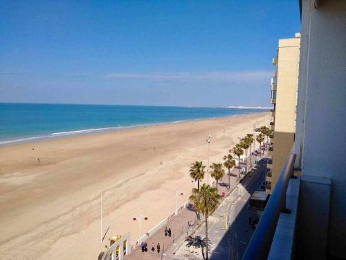 vistas a una playa con palmeras y al océano en El Mirador de la Playa Cortadura Grupo AC Gestion, en Cádiz