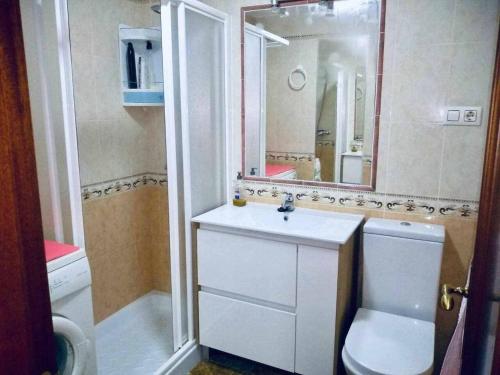 a bathroom with a sink and a toilet and a mirror at El Mirador de la Playa Cortadura Grupo AC Gestion in Cádiz