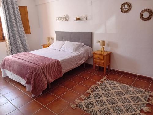 ein Schlafzimmer mit einem Bett und Fliesenboden in der Unterkunft Cuevas El Lago de Castilléjar in Castilléjar