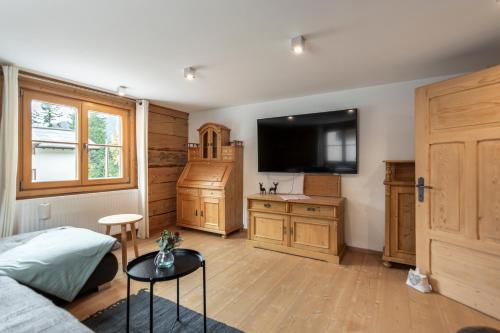 a living room with a couch and a tv in a room at Berghof Ferienhaus in Schröcken