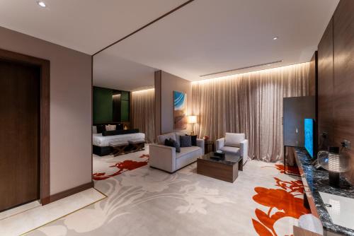Lilac Park Hotel في تبوك: غرفة معيشة مع أريكة وغرفة نوم