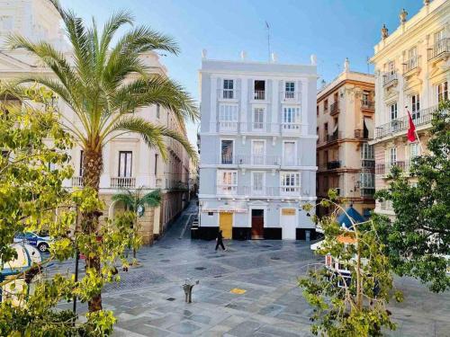 une rue de la ville avec des bâtiments et un palmier dans l'établissement El Chicuco en el corazón de Cádiz Grupo AC Gestion, à Cadix