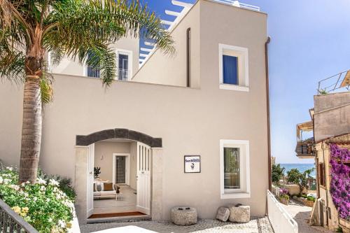 a house with a palm tree in front of it at PALAZZO SAN ROCCO in Sperlonga