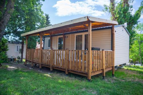 a wooden cabin with a roof on a yard at Camping Parc Bellevue in Cannes