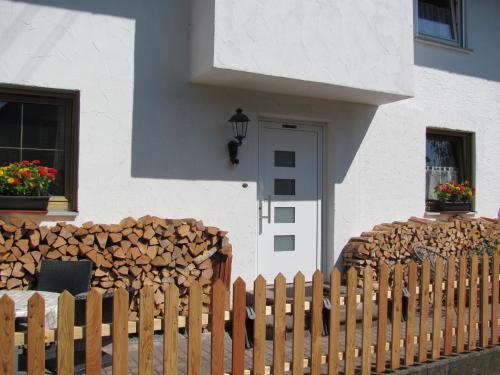 a wooden fence next to a house with a pile of wood at #5 Sonniges helles komf Einzelzimmer mit WG Bad W-Lan frei Airport nah gelegen in Trunkelsberg