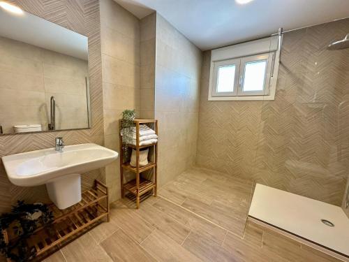 ein Badezimmer mit Waschbecken und Spiegel in der Unterkunft Apartamentos La Muralla Grupo AC Gestion in Cádiz