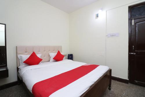 a bedroom with a large bed with red pillows at OYO Flagship Hotel Shreya in Bhubaneshwar