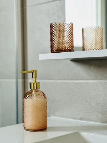 une bouteille de savon posée sur un lavabo de salle de bain dans l'établissement Charmant appartement rénové 6 personnes les Sables, à Les Sables-dʼOlonne