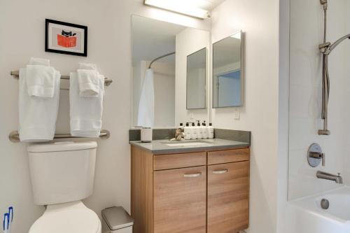 ein Badezimmer mit einem WC, einem Waschbecken und einem Spiegel in der Unterkunft Tysons Corner 1br w concierge wd nr bars WDC-811 