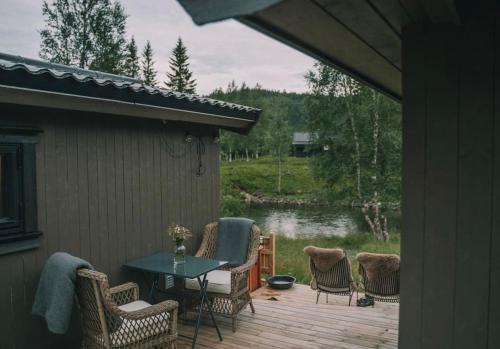 a patio with a table and chairs and a pond at Ådalsvollen retreat in Verdal