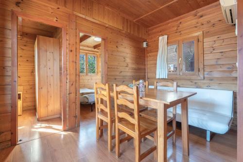 - une salle à manger avec une table et des chaises dans une cabine dans l'établissement Cabaña Madera A, à Bárig