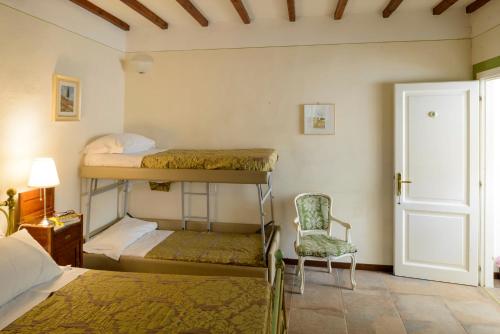 een slaapkamer met 2 stapelbedden en een stoel bij Donna Nobile in San Gimignano