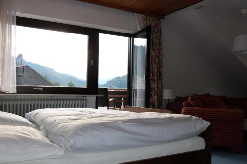 a bedroom with a bed and a large window at Haus am Wegle in Baiersbronn