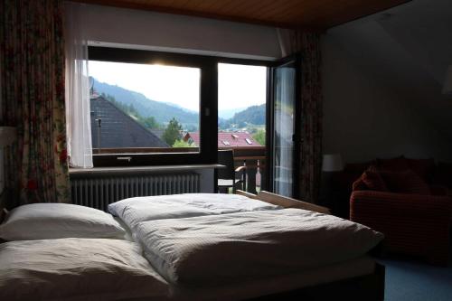 a bedroom with a bed and a large window at Haus am Wegle in Baiersbronn