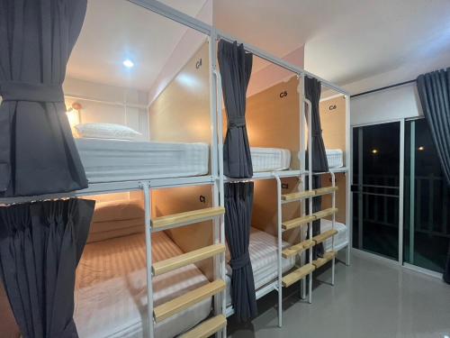 grupa łóżek piętrowych w pokoju w obiekcie BeHome and Hostel w mieście Chiang Mai