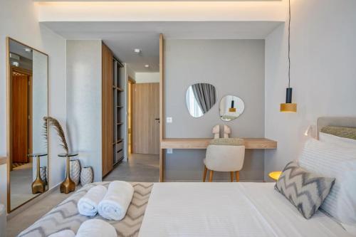 una camera da letto con un letto bianco e una scrivania di Skyline Villas, By Hellocrete ad Angelianá