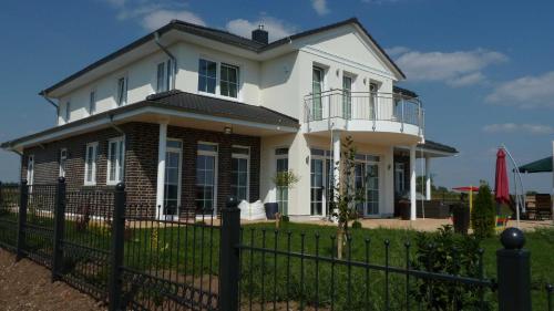 una casa bianca con una recinzione di fronte di Villa Toskana Rothenburg a Linden