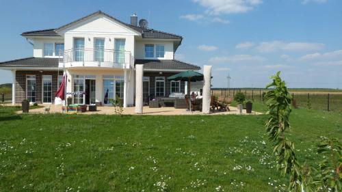 una grande casa bianca con un prato di Villa Toskana Rothenburg a Linden