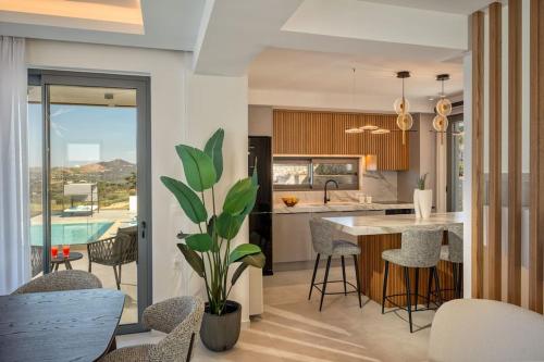 una cucina con tavolo, sedie e piscina di Skyline Villas, By Hellocrete ad Angelianá
