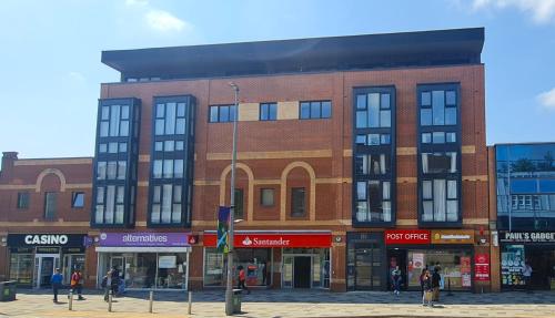 a brick building with people walking in front of it at Premium CITY APARTMENT near Harry Potter Studio and Luton Airport in Hemel Hempstead