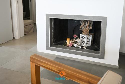 a fireplace in a living room with a fire place at Stanze VILLA DEL CONTE a Punta Prosciutto by SalentoGo in Punta Prosciutto