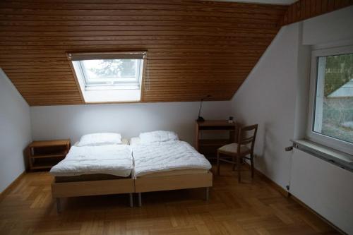 a bedroom with a bed and a window and a chair at Wohnen im Wald in Alte Drusel