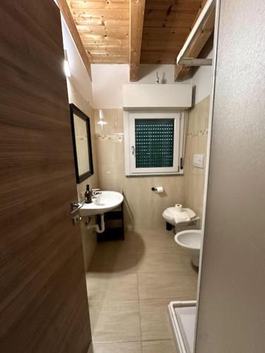ein Bad mit 2 Waschbecken, einem WC und einem Fenster in der Unterkunft Lodi Suite in Mailand
