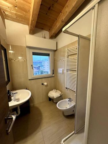 ein Bad mit 2 Waschbecken, einem WC und einem Fenster in der Unterkunft Lodi Suite in Mailand