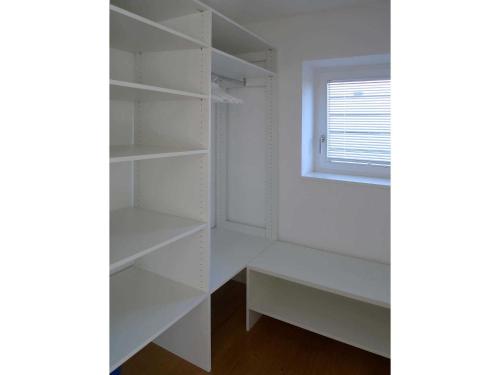 a room with white shelves and a window at Ferienwohnung Peterberg in Kirchzarten
