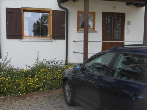 Allgäustüble في اوبرستوفن: سيارة سوداء متوقفة أمام منزل