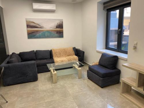 a living room with a couch and a glass table at Ivory Style Maisonette near Downtown in Heraklio