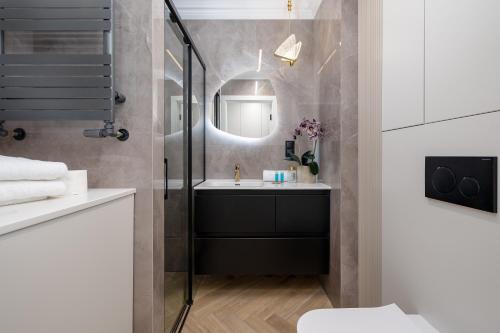 a bathroom with a sink and a mirror at Hanza Tower Studio 317 in Szczecin