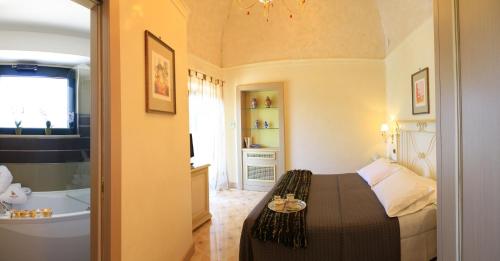 a bedroom with a bed and a bathroom with a tub at Villa Rosa Antico Dimora Storica in Otranto