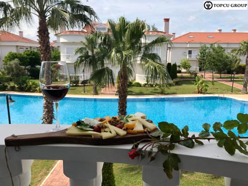 einen Tisch mit einem Teller Essen und einem Glas Wein in der Unterkunft BlueHomes Villas in Belek