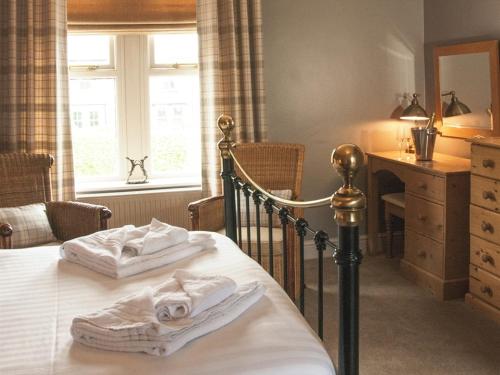 een slaapkamer met een bed met witte handdoeken bij The Poplars Rooms & Cottages in Thirsk