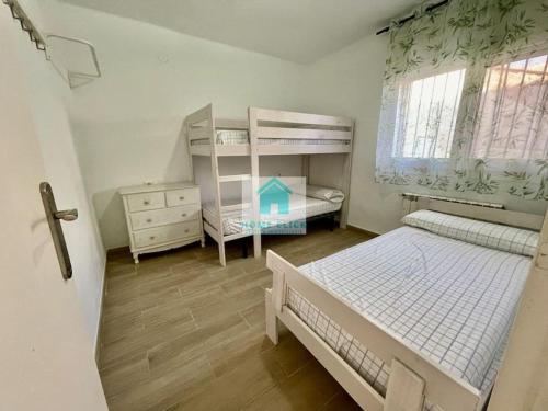 מיטה או מיטות קומותיים בחדר ב-Apartamento en playa cristal