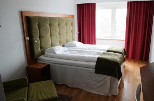 a bedroom with a large bed and red curtains at Quality Hotel Grand, Borås in Borås