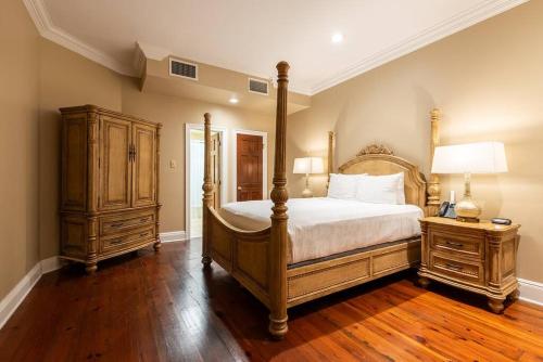 um quarto com uma cama de dossel e piso em madeira em St. Philip Manor French Quarter em Nova Orleães
