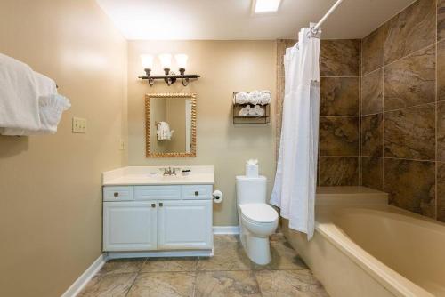 een badkamer met een toilet, een bad en een wastafel bij St. Philip Manor French Quarter in New Orleans